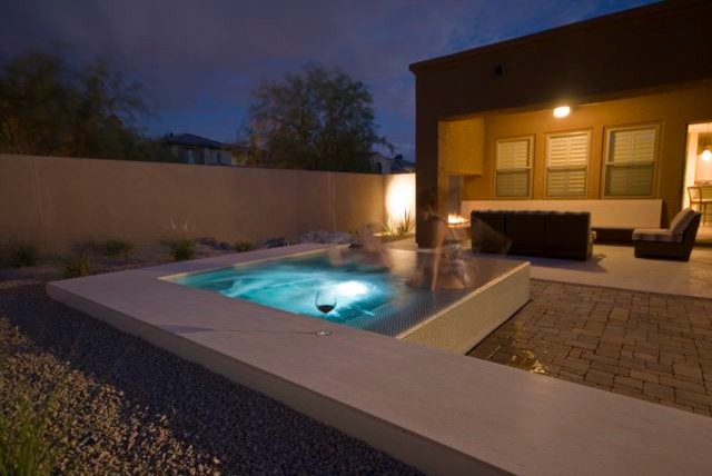 На фото: маленький бассейн-инфинити произвольной формы на заднем дворе в стиле модернизм с джакузи и мощением клинкерной брусчаткой для на участке и в саду