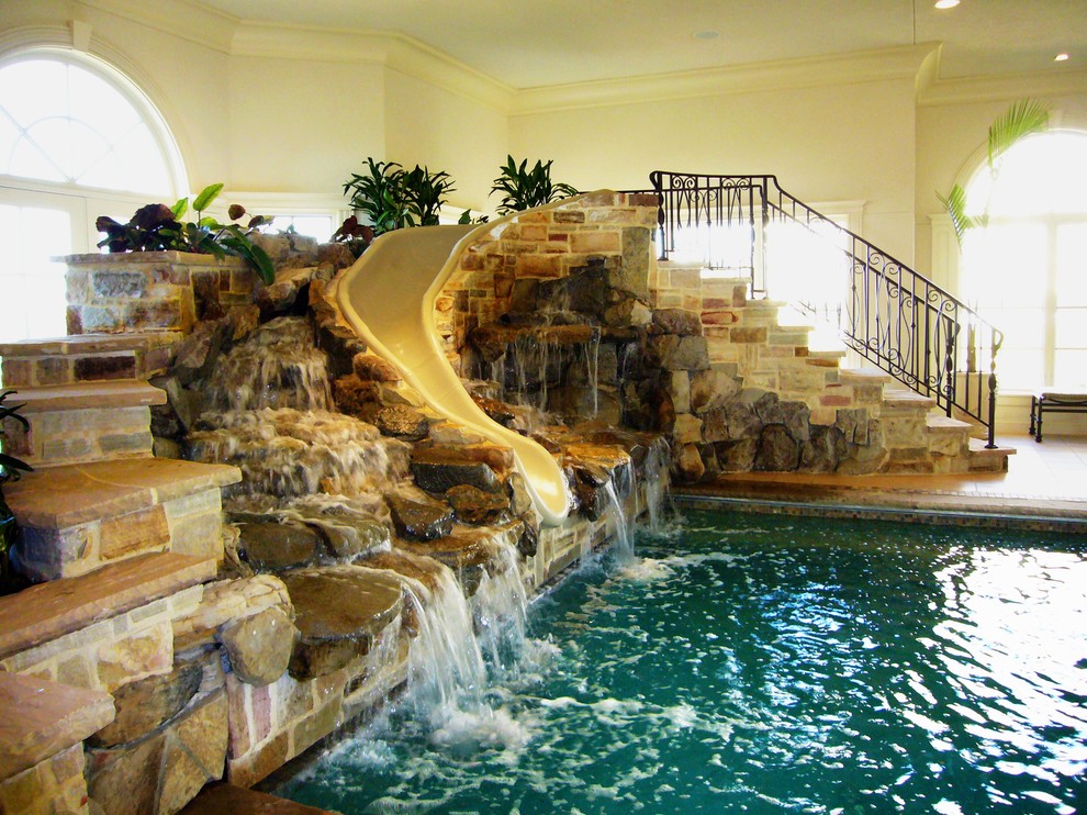 Idee per una piscina coperta american style rettangolare con pavimentazioni in pietra naturale e un acquascivolo
