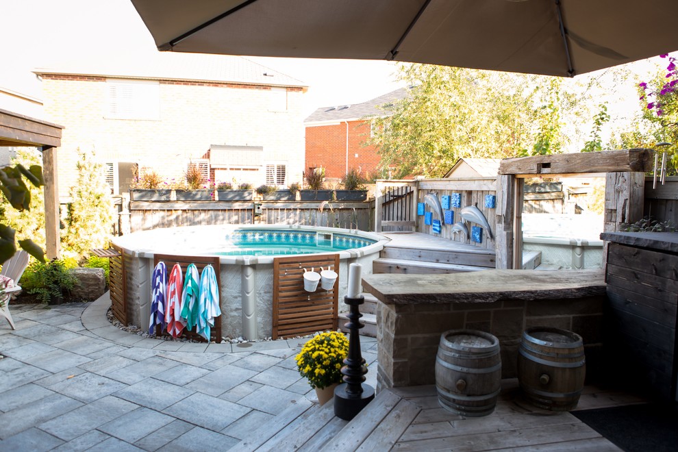 Imagen de piscina con fuente de estilo americano de tamaño medio en patio trasero con entablado