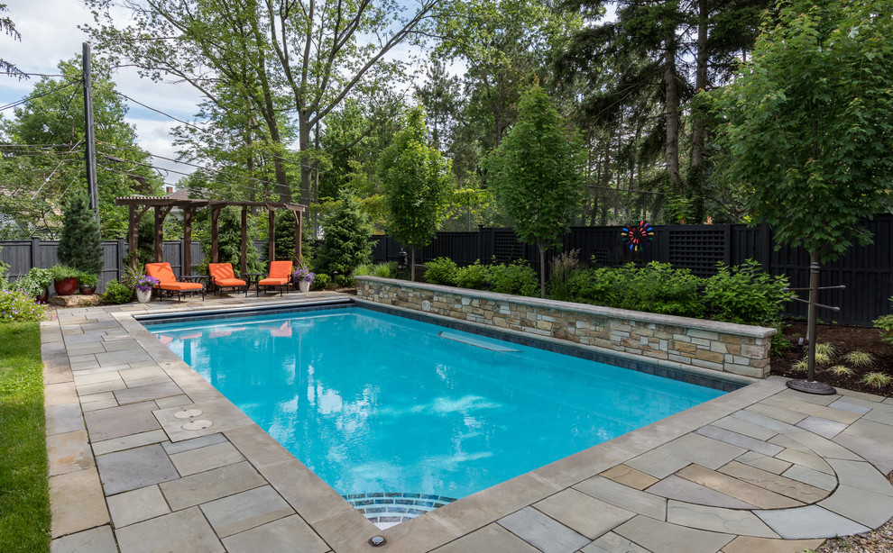 Esempio di una piscina monocorsia chic rettangolare di medie dimensioni e dietro casa con fontane e pavimentazioni in pietra naturale