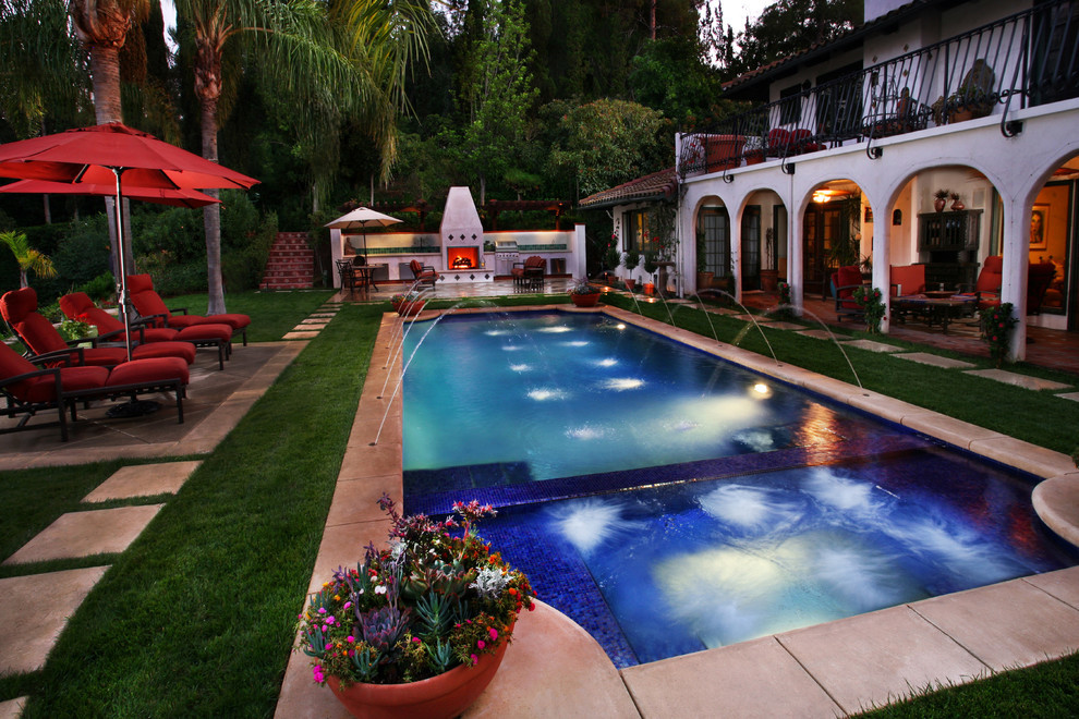 Immagine di una piscina monocorsia mediterranea personalizzata di medie dimensioni e dietro casa con fontane e lastre di cemento