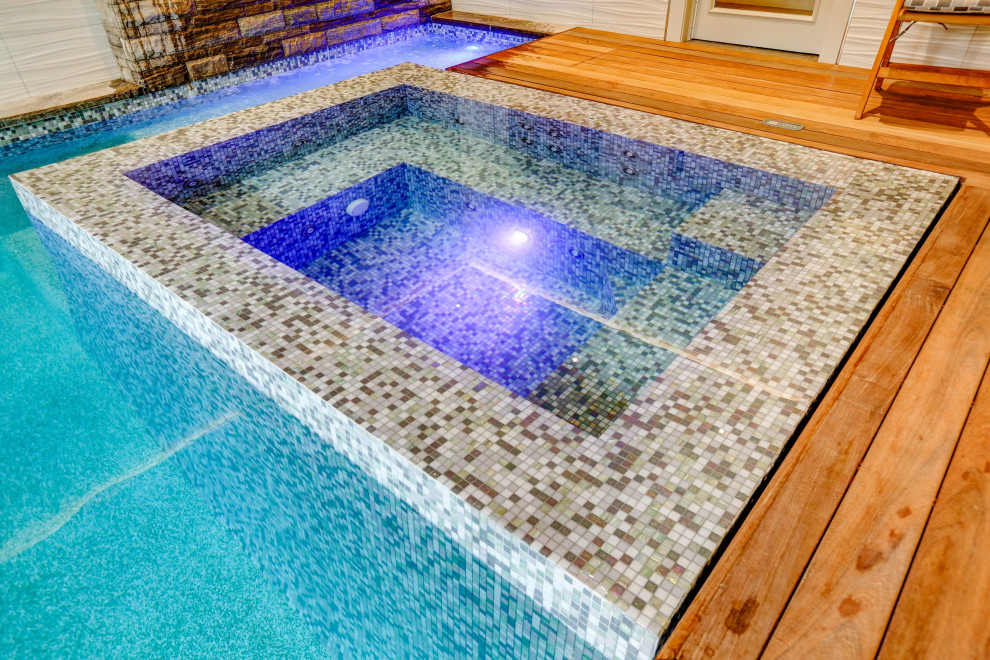 Idée de décoration pour une petite piscine intérieure bohème rectangle avec un bain bouillonnant et une terrasse en bois.