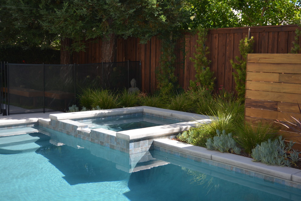 Inspiration pour une petite piscine arrière design sur mesure avec un bain bouillonnant et une terrasse en bois.