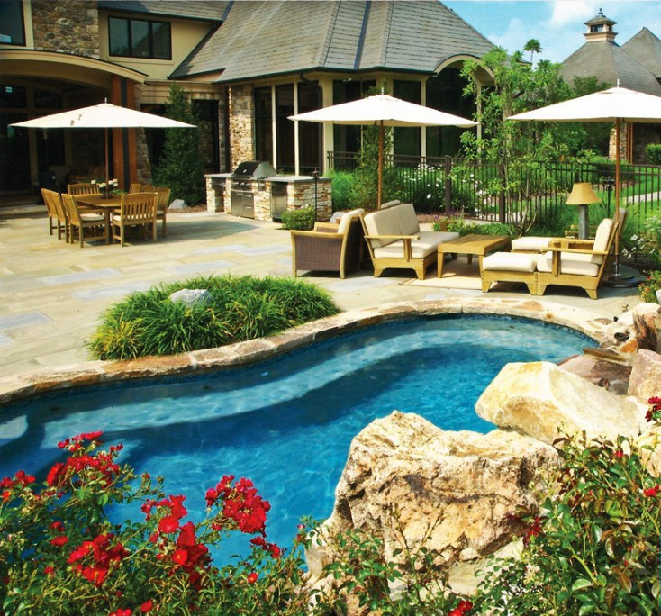Пример оригинального дизайна: маленький естественный бассейн произвольной формы на заднем дворе в стиле неоклассика (современная классика) с фонтаном и покрытием из каменной брусчатки для на участке и в саду