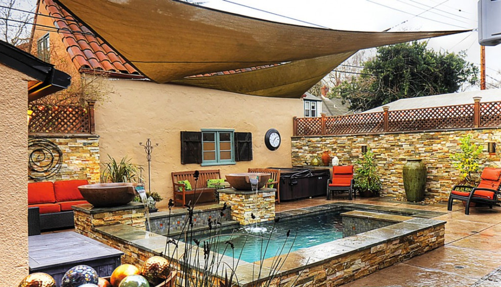 Foto de piscina con fuente natural clásica renovada pequeña rectangular en patio trasero con suelo de hormigón estampado
