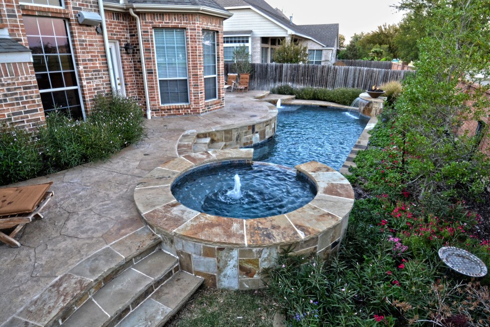 Diseño de piscina con fuente actual pequeña a medida en patio trasero con suelo de hormigón estampado
