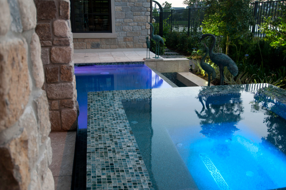 Imagen de piscinas y jacuzzis infinitos actuales pequeños rectangulares en patio con suelo de baldosas