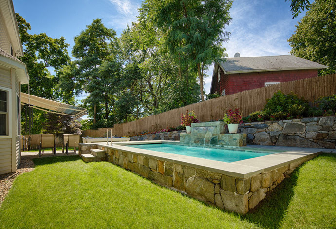 Foto de piscina con fuente clásica pequeña rectangular en patio trasero