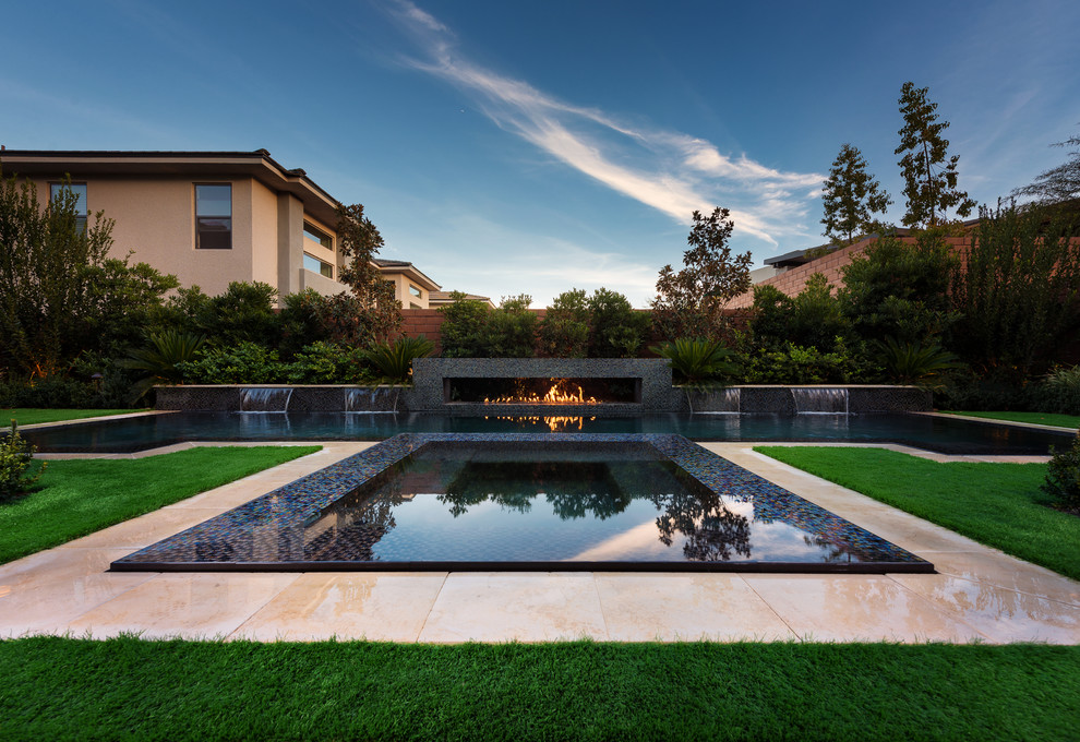 Esempio di una piccola piscina a sfioro infinito moderna personalizzata dietro casa con una vasca idromassaggio
