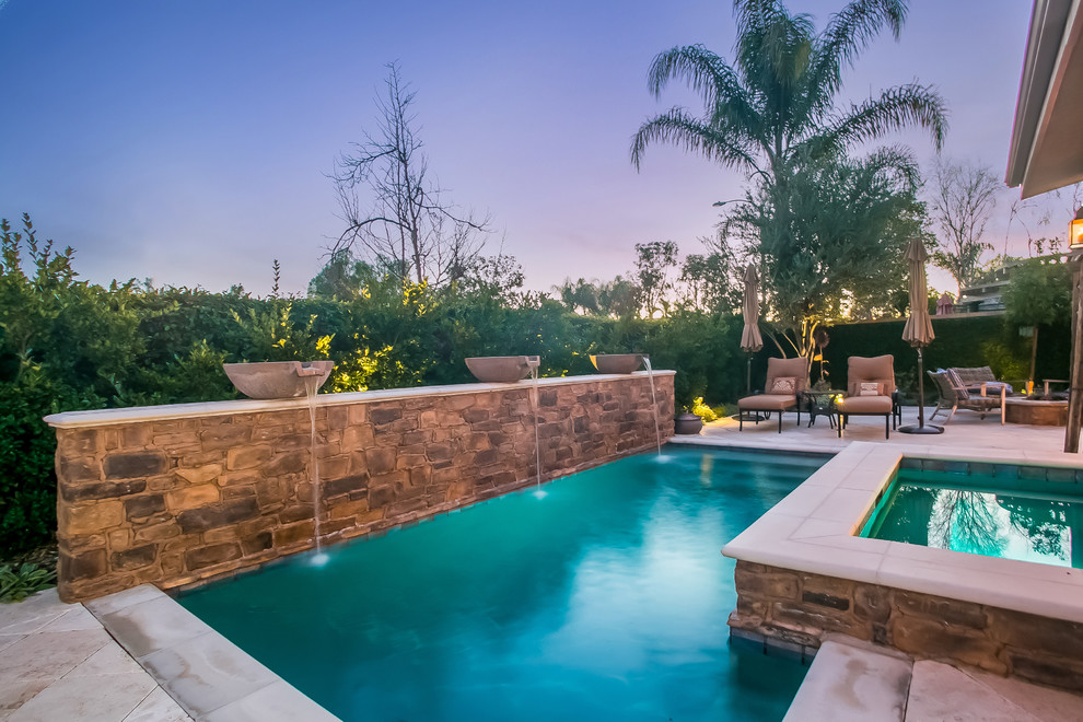 Kleiner Mediterraner Pool hinter dem Haus in rechteckiger Form mit Natursteinplatten in Los Angeles
