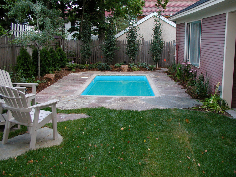 Foto de piscina tradicional pequeña rectangular en patio trasero con adoquines de piedra natural