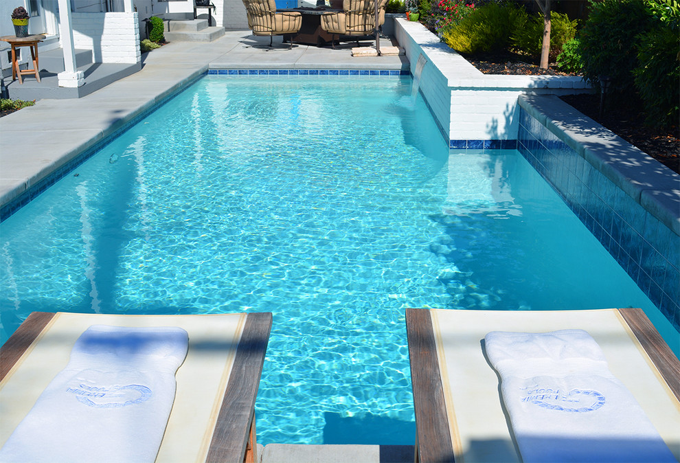Exemple d'une petite piscine arrière moderne rectangle avec un point d'eau et des pavés en béton.