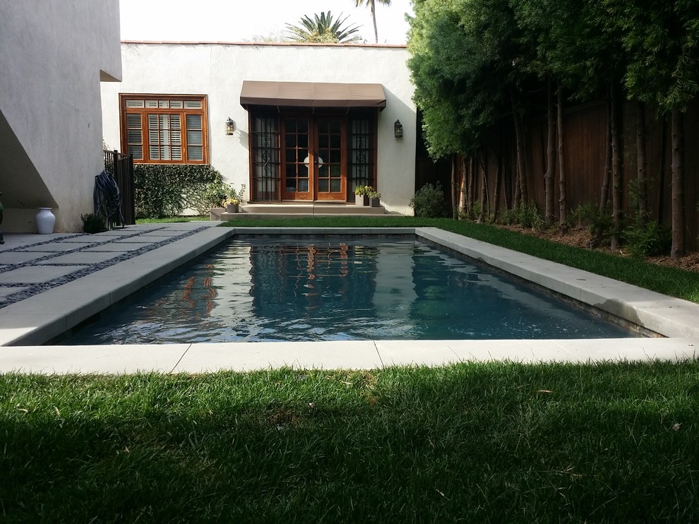 Imagen de piscina alargada moderna pequeña rectangular en patio trasero con adoquines de hormigón