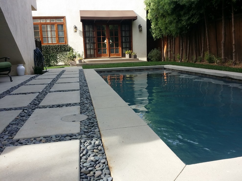 На фото: маленький прямоугольный бассейн на заднем дворе в стиле модернизм с мощением тротуарной плиткой для на участке и в саду с