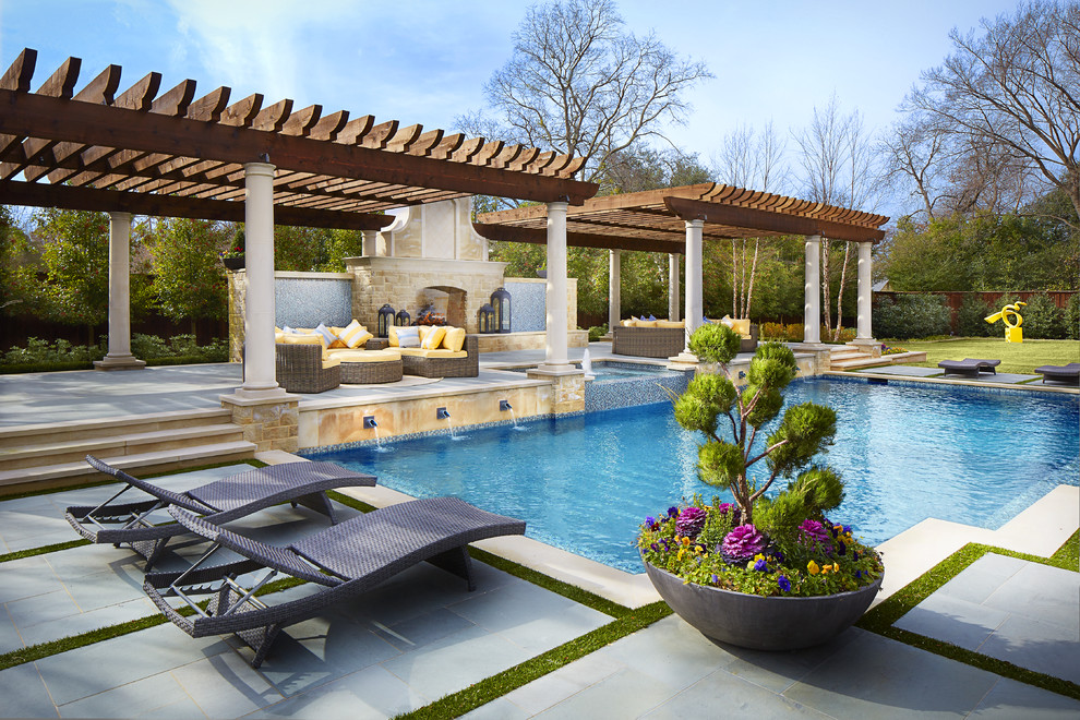 Expansive mediterranean back custom shaped swimming pool in Dallas with a water feature and concrete slabs.