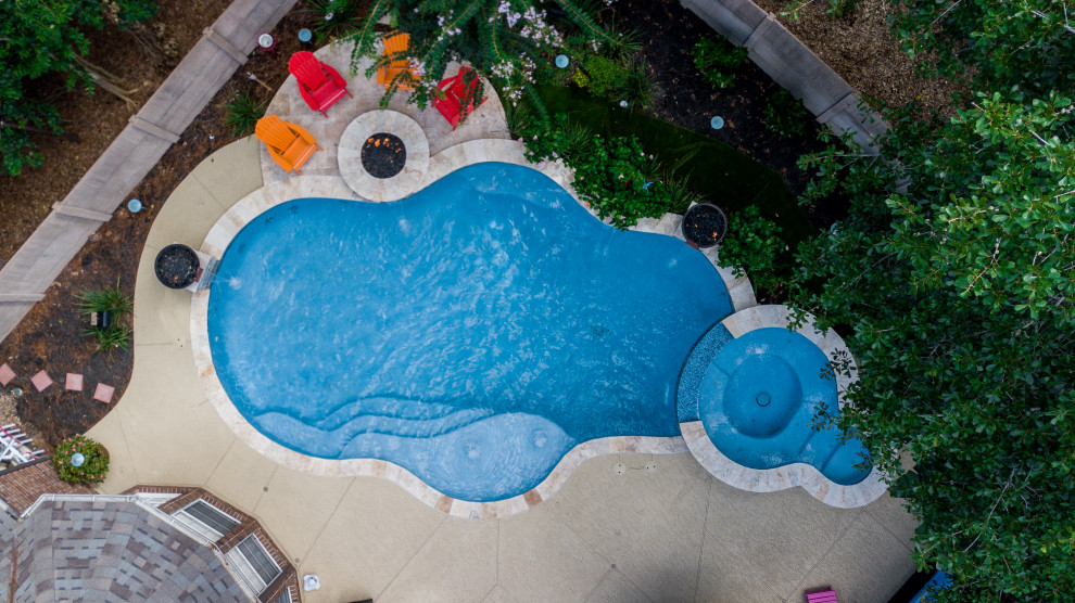 На фото: бассейн среднего размера, произвольной формы на заднем дворе в морском стиле с