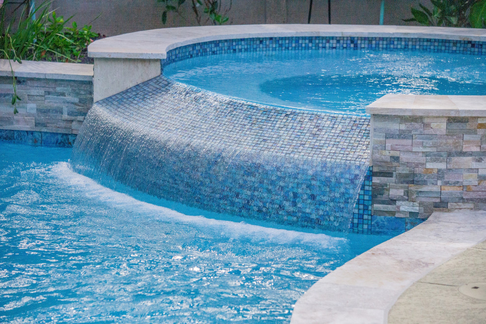 На фото: бассейн среднего размера, произвольной формы на заднем дворе в морском стиле
