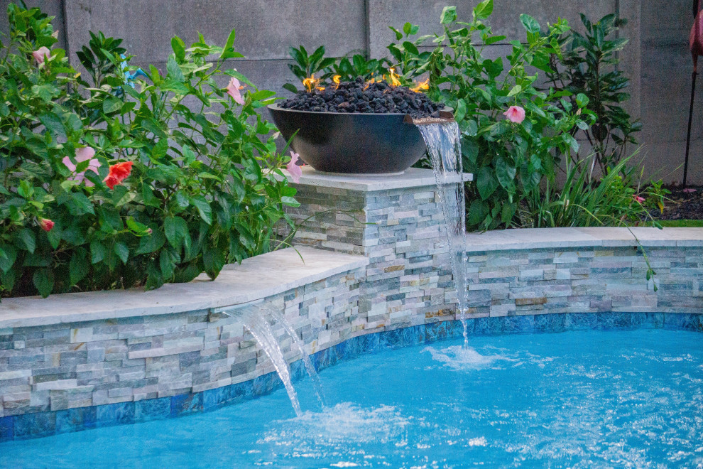 Pool - mid-sized tropical backyard custom-shaped pool idea in Houston