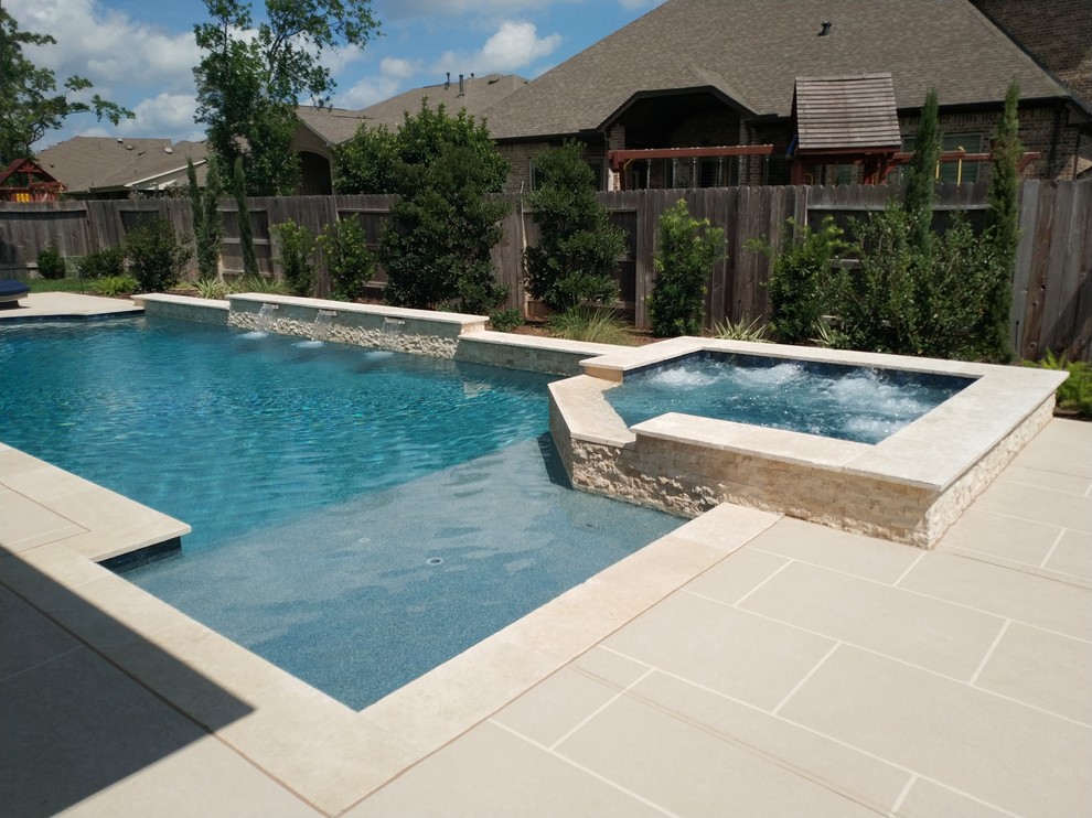 Immagine di una piscina monocorsia classica rettangolare di medie dimensioni e dietro casa con una vasca idromassaggio e pavimentazioni in cemento