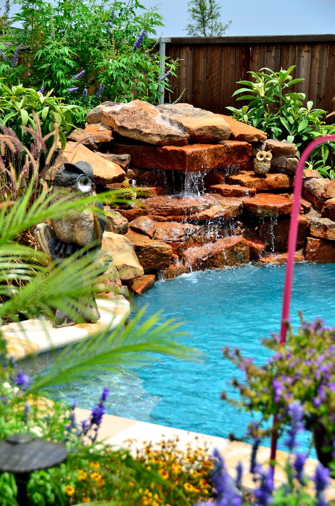 Aménagement d'une piscine naturelle et arrière exotique de taille moyenne et sur mesure avec un point d'eau et une terrasse en bois.