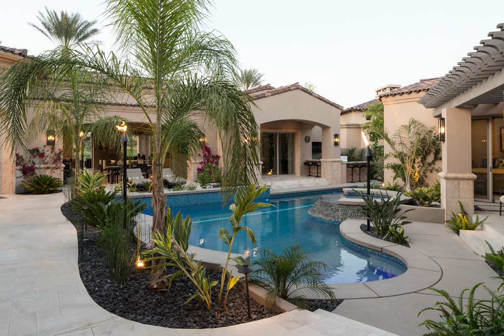 Diseño de piscinas y jacuzzis naturales tropicales de tamaño medio a medida en patio trasero con adoquines de hormigón