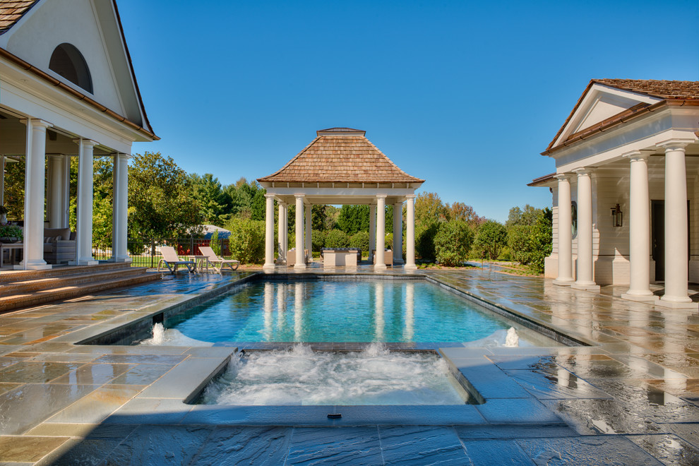 Пример оригинального дизайна: прямоугольный бассейн среднего размера в доме в стиле неоклассика (современная классика) с домиком у бассейна и покрытием из каменной брусчатки