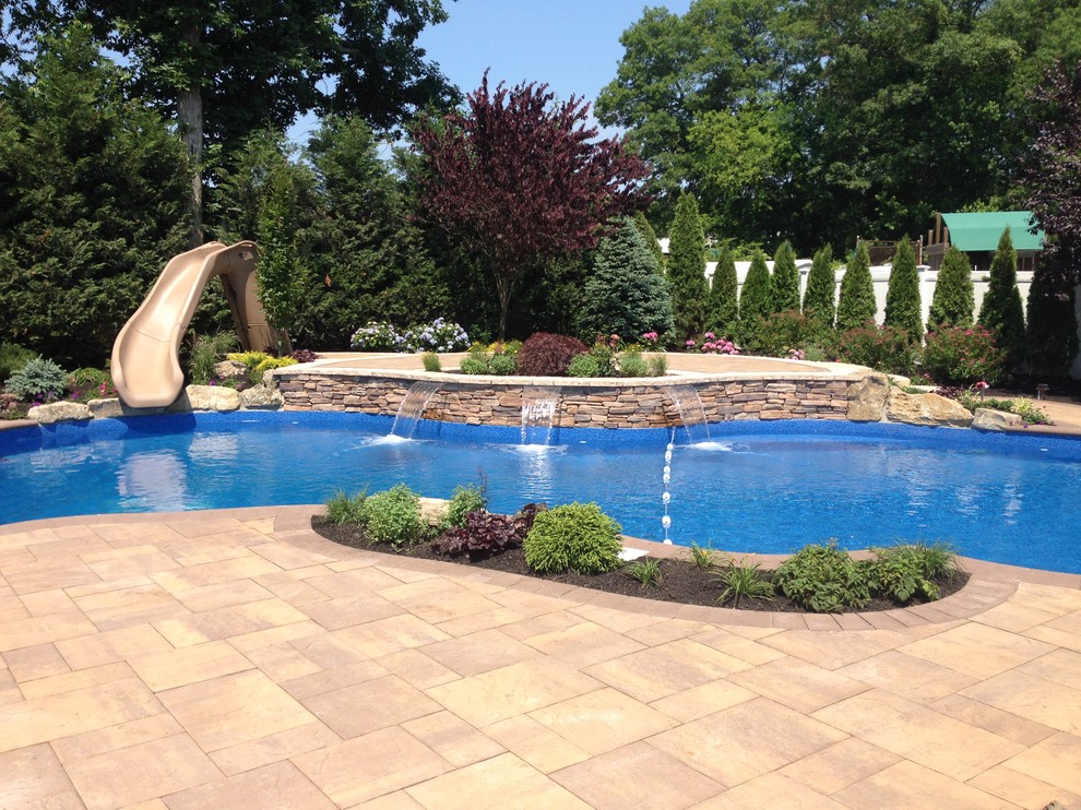 На фото: бассейн среднего размера, произвольной формы на заднем дворе в современном стиле с водной горкой и мощением тротуарной плиткой