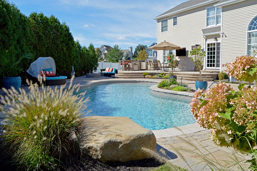 На фото: бассейн произвольной формы на заднем дворе в стиле шебби-шик с фонтаном и мощением тротуарной плиткой