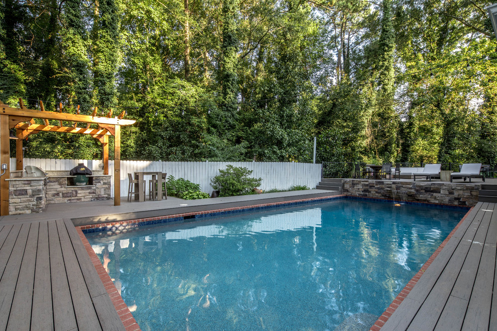 Immagine di una grande piscina monocorsia american style rettangolare dietro casa con pedane