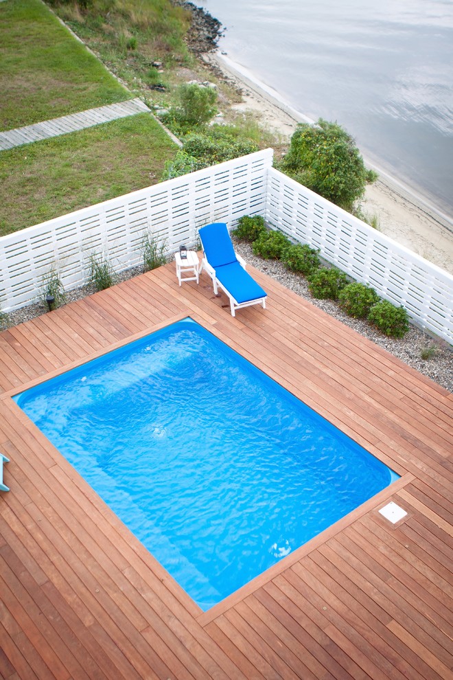 Inspiration pour une piscine traditionnelle rectangle avec une terrasse en bois.