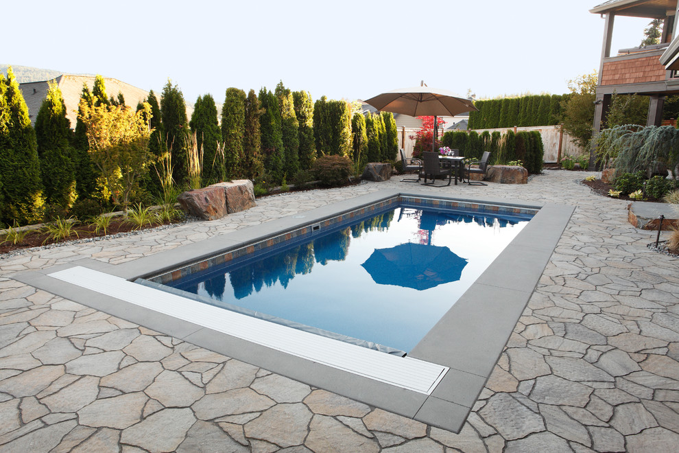 На фото: прямоугольный бассейн среднего размера на заднем дворе в стиле рустика с фонтаном и мощением тротуарной плиткой с