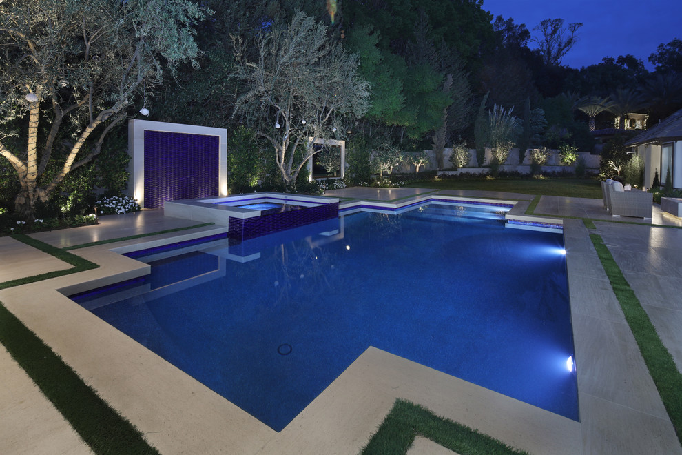 Ejemplo de piscina con fuente contemporánea grande rectangular en patio trasero con adoquines de piedra natural