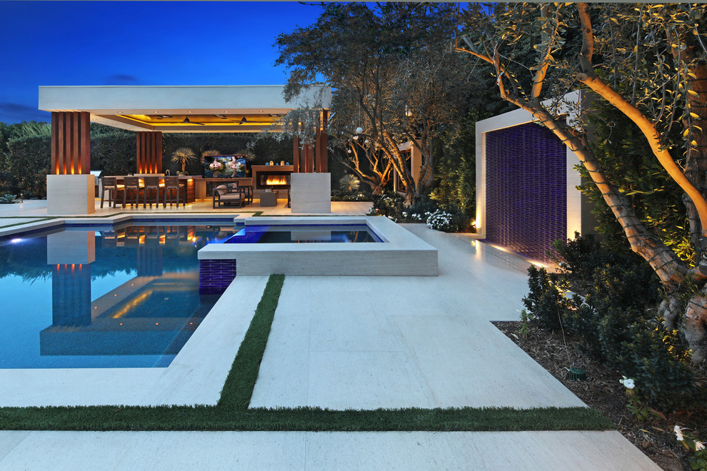 Foto de piscina con fuente contemporánea grande rectangular en patio trasero con adoquines de piedra natural
