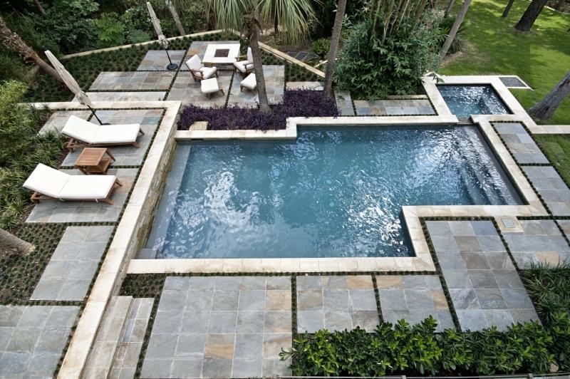 Idéer för en stor modern pool på baksidan av huset, med kakelplattor