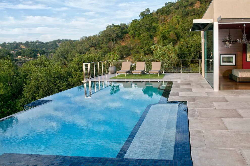 Стильный дизайн: большой прямоугольный бассейн-инфинити на заднем дворе в стиле модернизм с покрытием из плитки - последний тренд