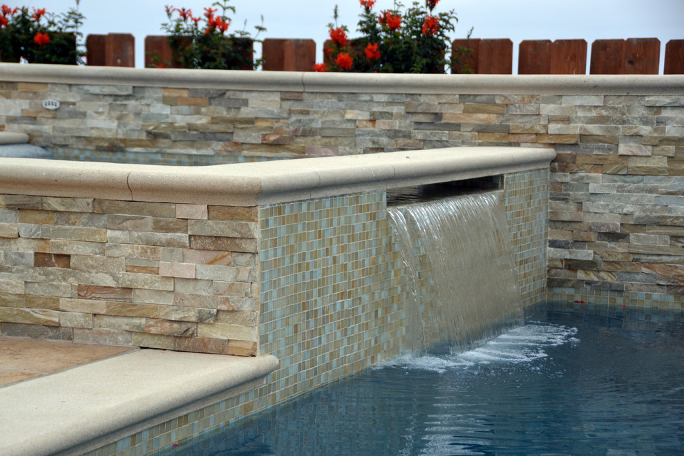 На фото: огромный бассейн на заднем дворе в средиземноморском стиле с покрытием из каменной брусчатки с