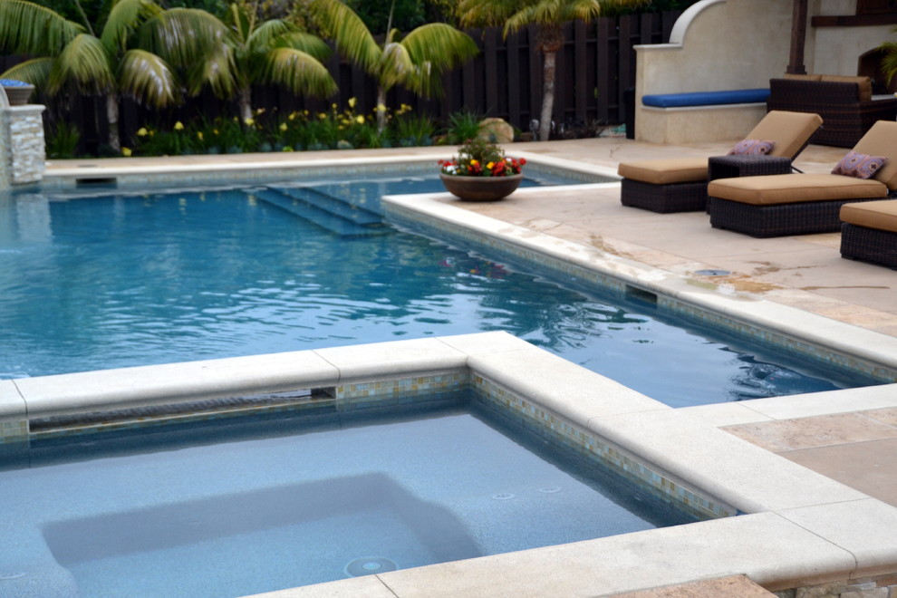 This is an example of an expansive mediterranean back swimming pool in Orange County with natural stone paving.