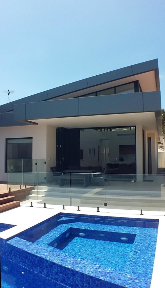 This is an example of a medium sized modern back rectangular swimming pool in Adelaide with a pool house and tiled flooring.