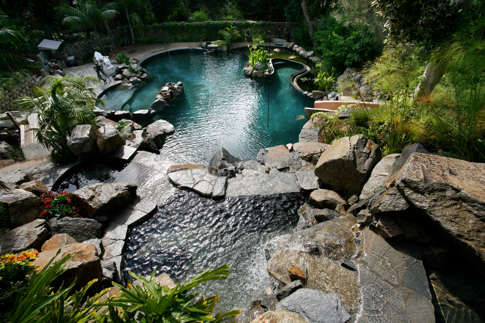 Großer Klassischer Schwimmteich hinter dem Haus in individueller Form mit Wasserrutsche und Natursteinplatten in San Diego
