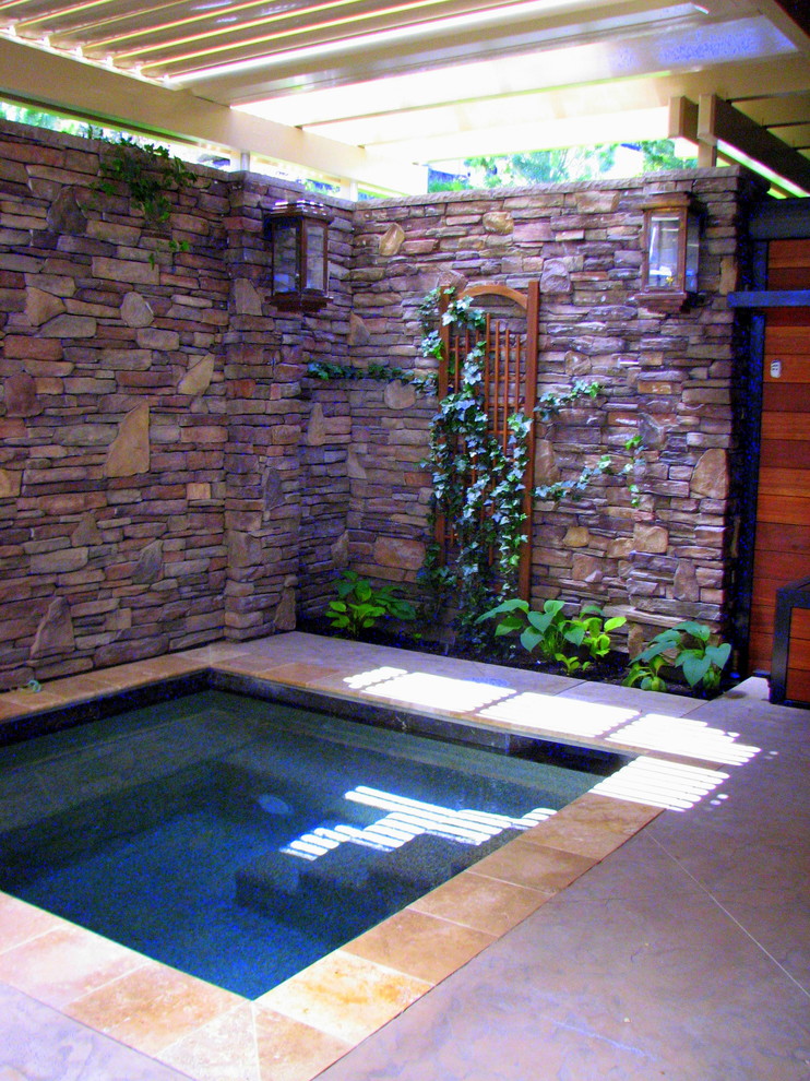Foto di una piscina minimal con una vasca idromassaggio e cemento stampato