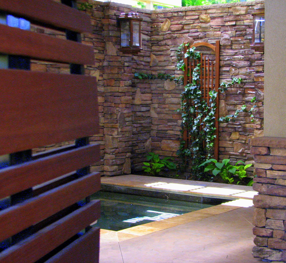Immagine di una piscina minimal con una vasca idromassaggio e cemento stampato