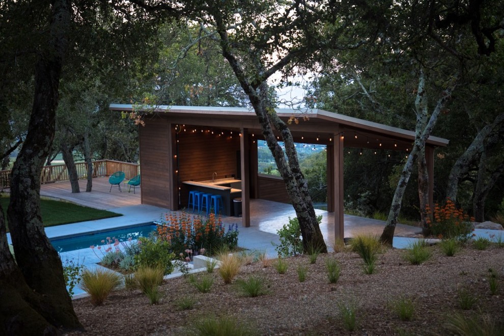 Diseño de casa de la piscina y piscina contemporánea de tamaño medio rectangular en patio trasero con losas de hormigón