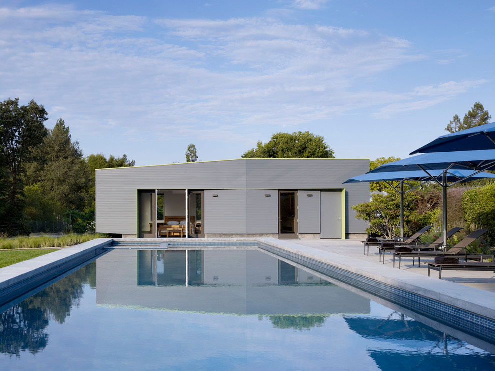 Ispirazione per una piscina design rettangolare di medie dimensioni e davanti casa con lastre di cemento