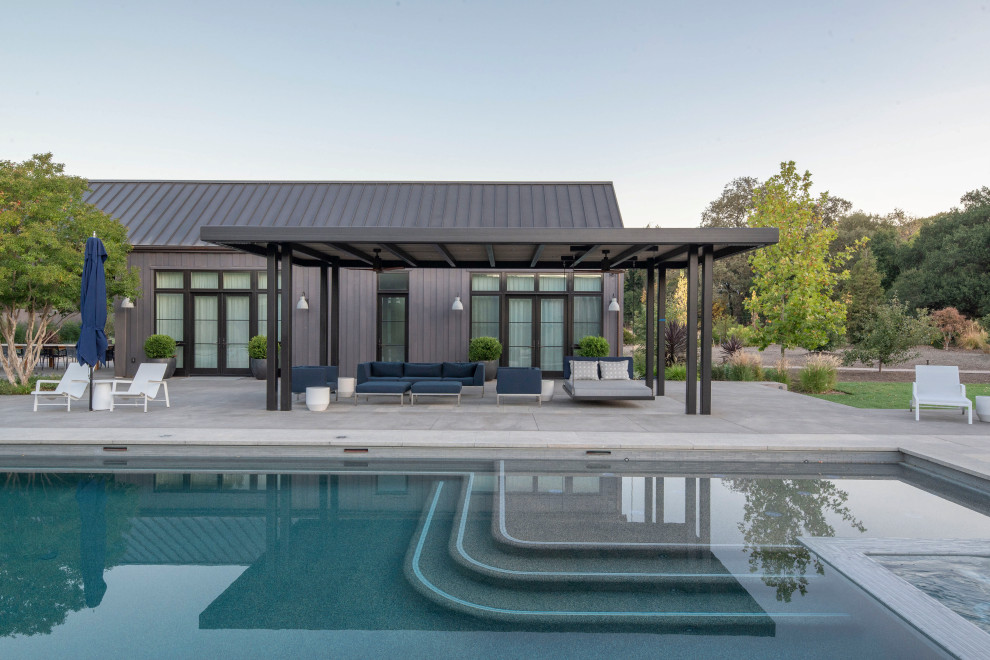 Ispirazione per una grande piscina country rettangolare dietro casa con pavimentazioni in cemento
