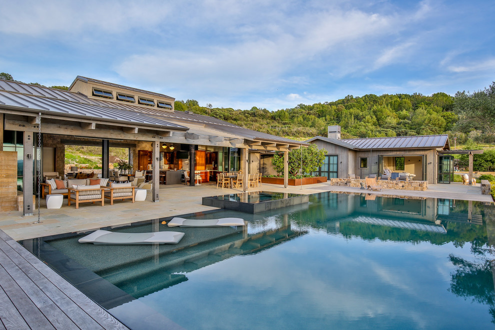 Immagine di una piscina country rettangolare dietro casa con una vasca idromassaggio