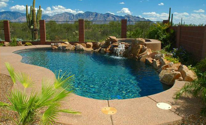 Cette image montre une piscine naturelle et arrière sud-ouest américain de taille moyenne et sur mesure avec un bain bouillonnant et des pavés en béton.