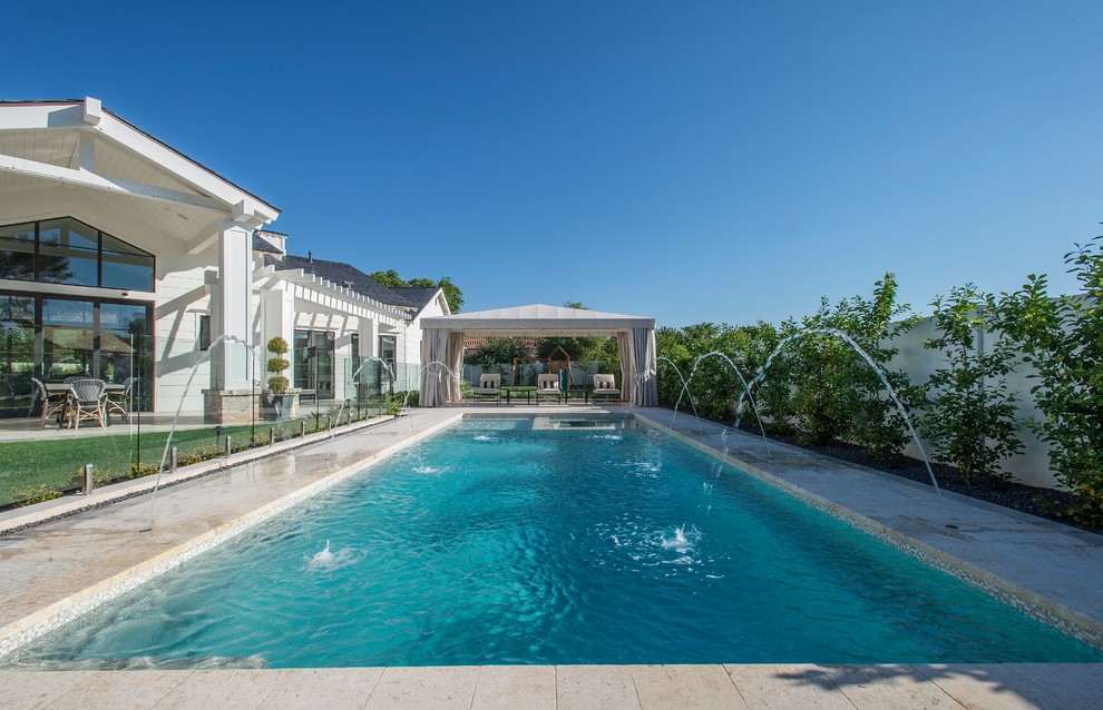 Foto de piscina con fuente alargada clásica renovada grande rectangular en patio trasero con adoquines de hormigón