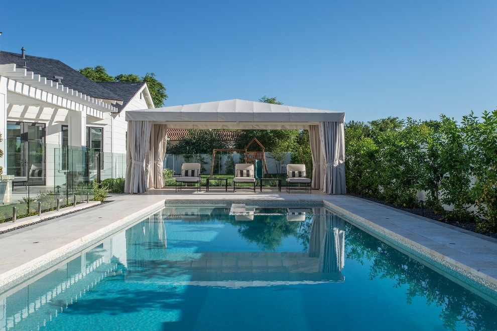 Foto de piscina alargada clásica renovada rectangular en patio trasero