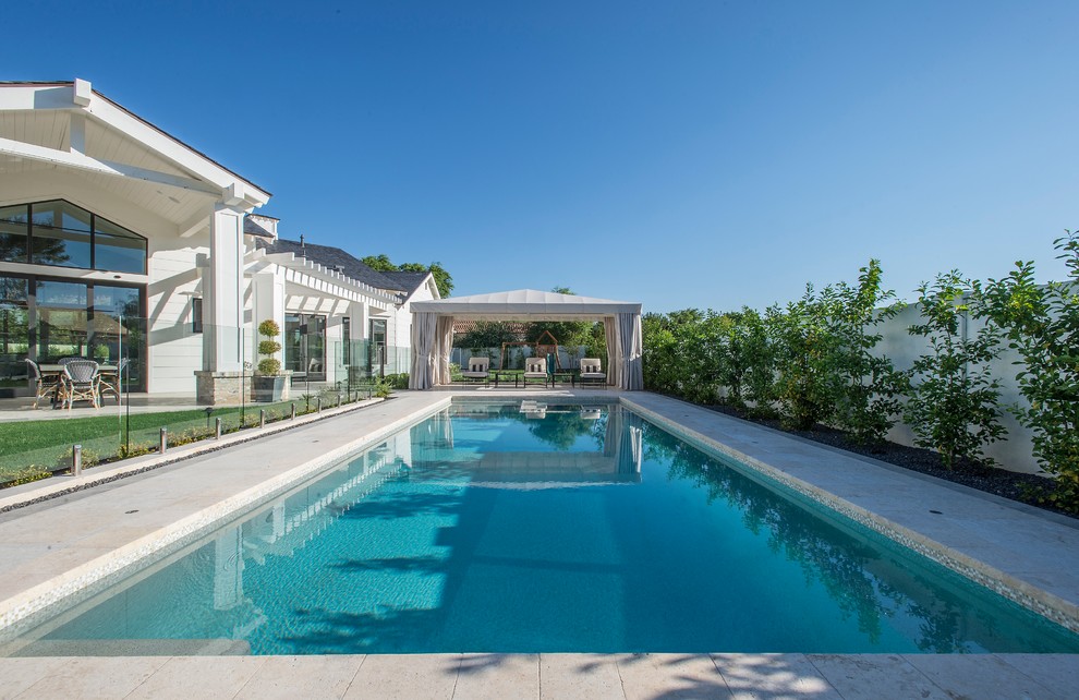 Ejemplo de piscina alargada clásica renovada rectangular en patio trasero