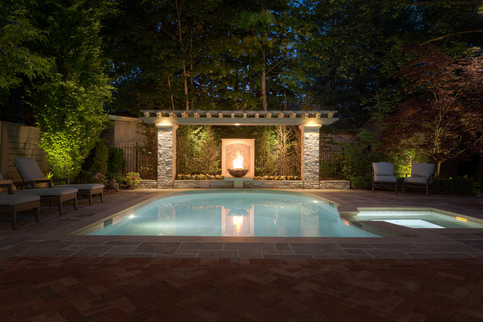 Cette image montre une piscine arrière traditionnelle de taille moyenne et sur mesure avec un point d'eau et des pavés en brique.